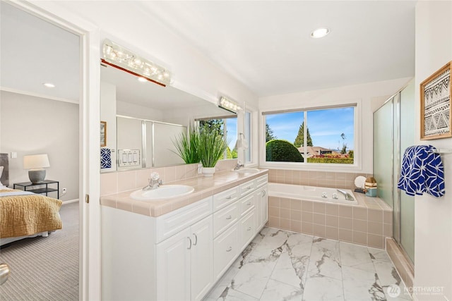 bathroom with a sink, a shower stall, double vanity, and marble finish floor