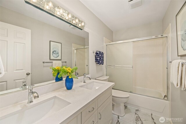 bathroom with double vanity, a sink, marble finish floor, and toilet