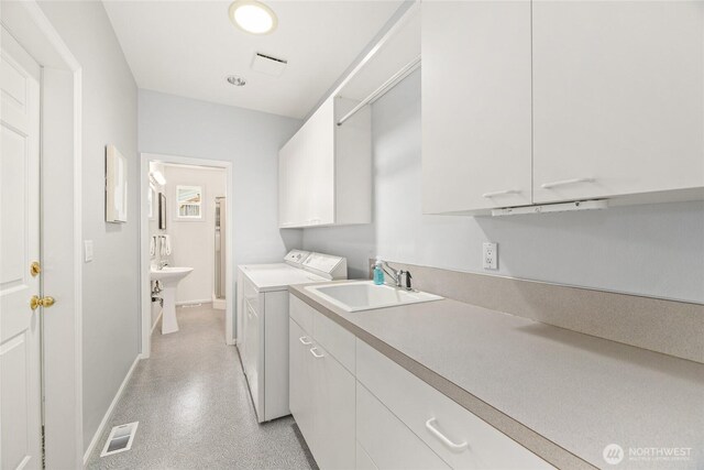 laundry area featuring visible vents, cabinet space, a sink, baseboards, and washer and dryer