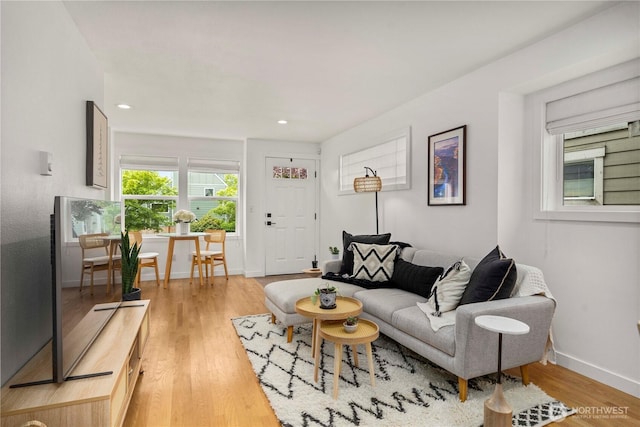 living area featuring recessed lighting, baseboards, and light wood finished floors