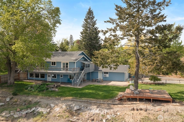 rear view of property with a patio area, a wooden deck, a yard, and fence