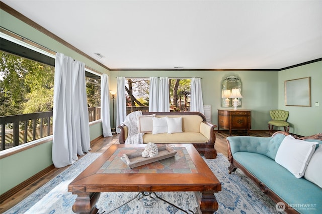 living room with crown molding, wood finished floors, and visible vents