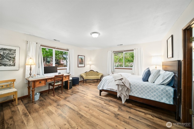 bedroom featuring light wood-style floors, baseboards, and visible vents
