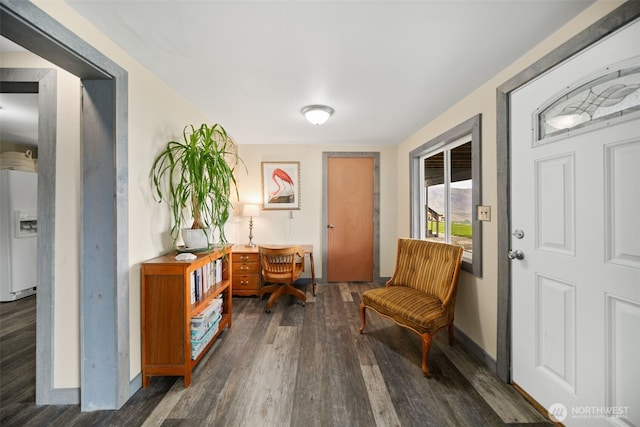 living area featuring baseboards and wood finished floors