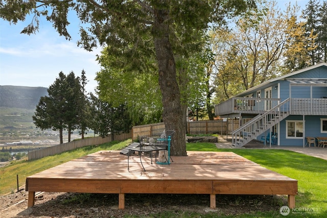 wooden terrace featuring a fenced backyard and stairs