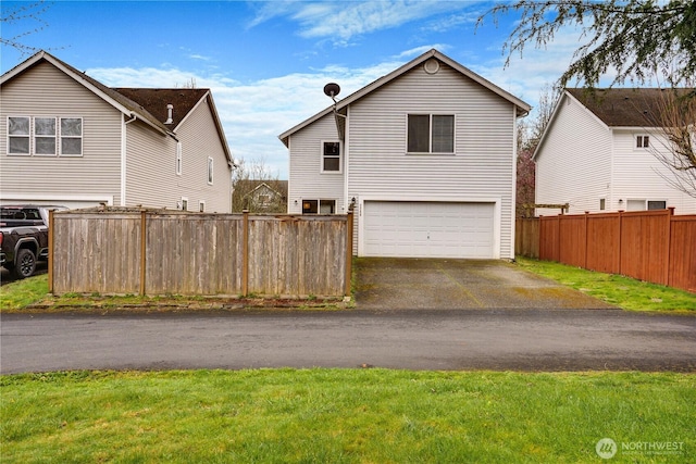view of front of property with driveway, fence, and a garage