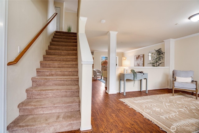 stairs with ornamental molding, baseboards, wood finished floors, and ornate columns