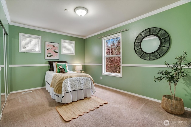 carpeted bedroom featuring visible vents, crown molding, and baseboards