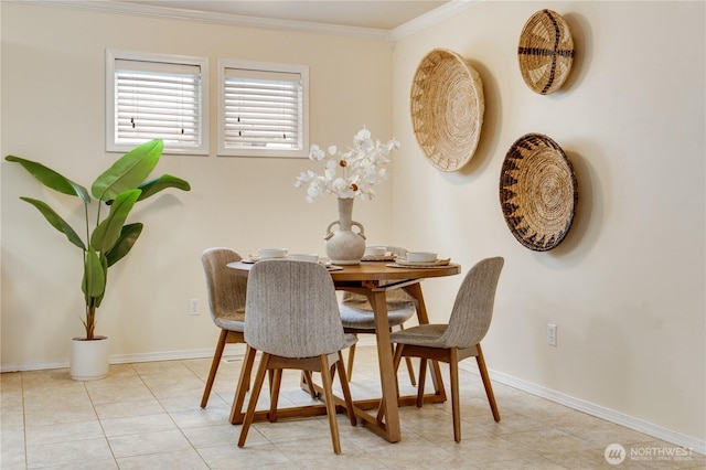 dining space with baseboards, light tile patterned flooring, and crown molding
