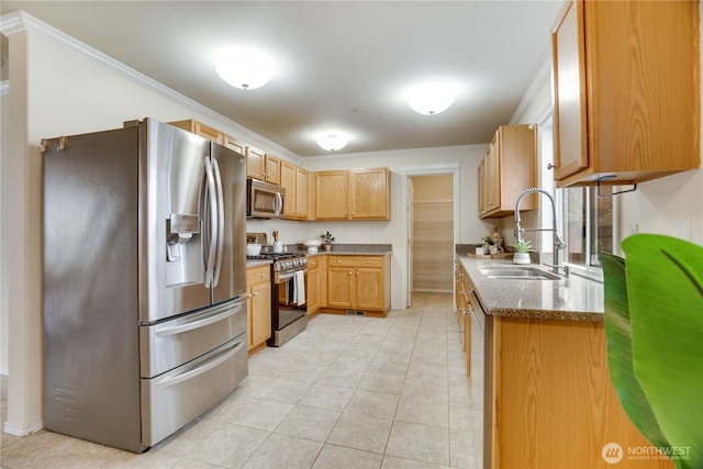 kitchen with dark stone counters, a sink, light tile patterned flooring, ornamental molding, and appliances with stainless steel finishes