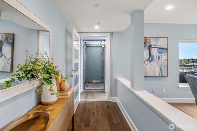 corridor featuring crown molding, a sink, baseboards, dark wood-style floors, and recessed lighting