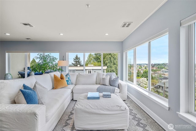 living room with visible vents, baseboards, and a healthy amount of sunlight