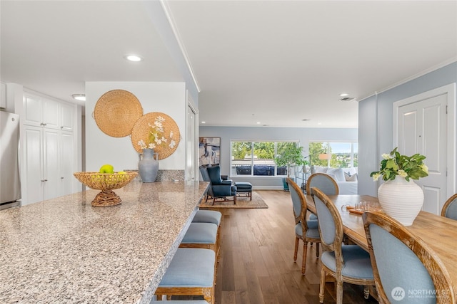 dining room featuring recessed lighting, ornamental molding, and wood finished floors