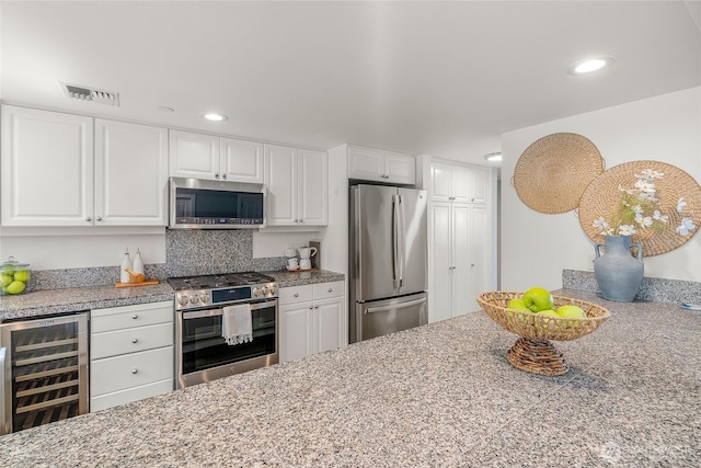 kitchen featuring visible vents, beverage cooler, recessed lighting, white cabinetry, and stainless steel appliances