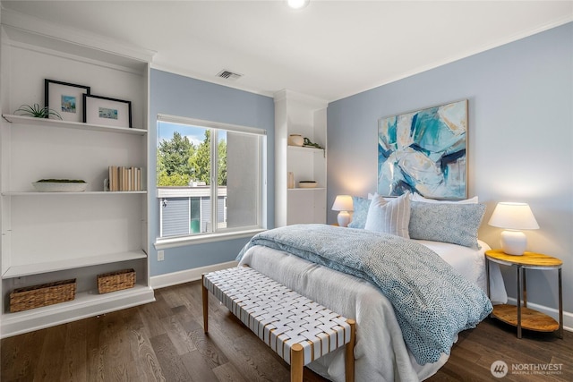 bedroom featuring crown molding, baseboards, wood finished floors, and visible vents