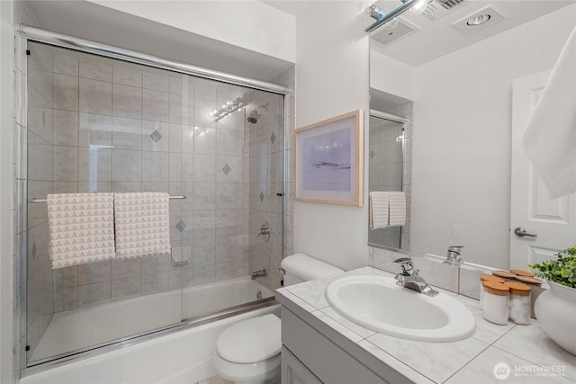 bathroom featuring toilet, visible vents, shower / bath combination with glass door, and vanity