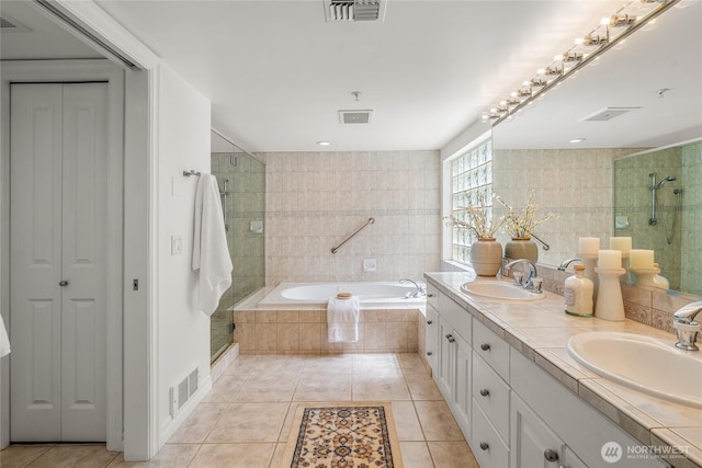 bathroom featuring a sink, tile patterned flooring, a shower stall, and visible vents