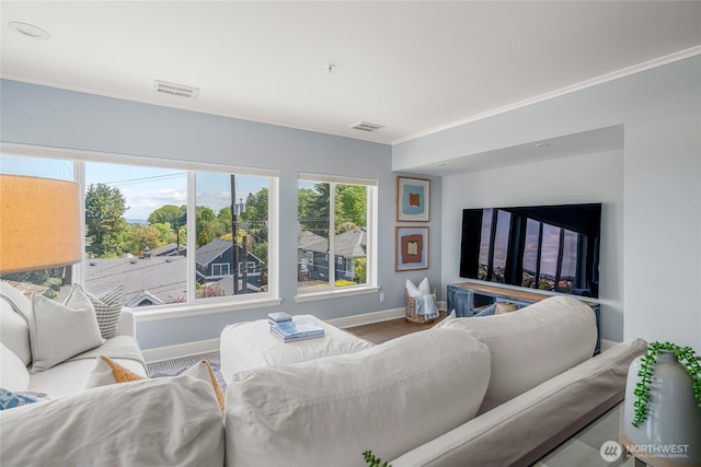 living area featuring crown molding, baseboards, and visible vents