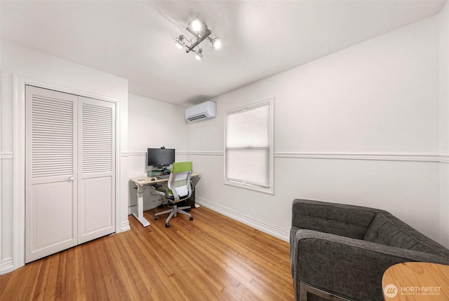 office with baseboards, a wall mounted AC, and wood finished floors