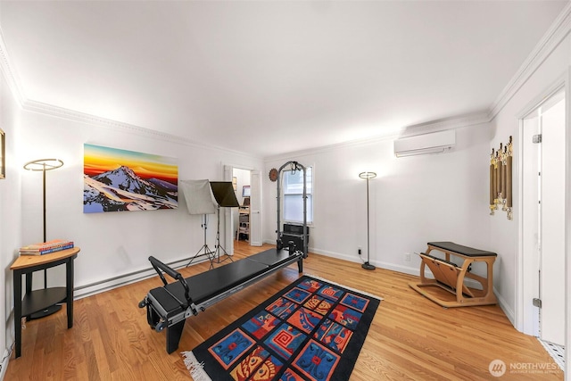 exercise area featuring crown molding, an AC wall unit, baseboards, and wood finished floors