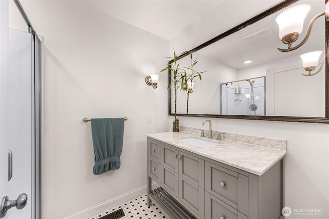 bathroom featuring vanity, baseboards, a stall shower, and visible vents
