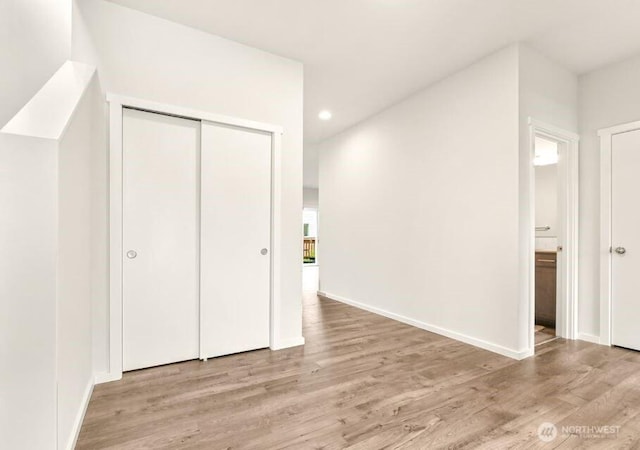 additional living space with baseboards, recessed lighting, and light wood-style flooring