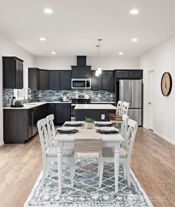 dining room with recessed lighting, baseboards, and light wood-type flooring