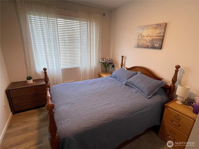 bedroom featuring baseboards and wood finished floors