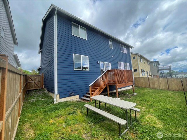 rear view of property featuring a deck, a gate, a fenced backyard, a yard, and stairs