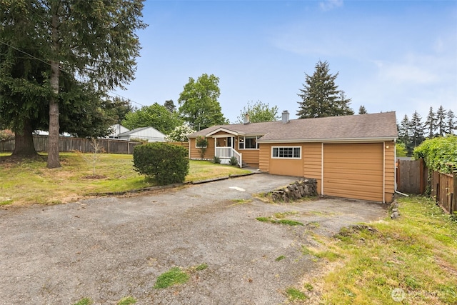view of front of property with driveway, a garage, and a chimney