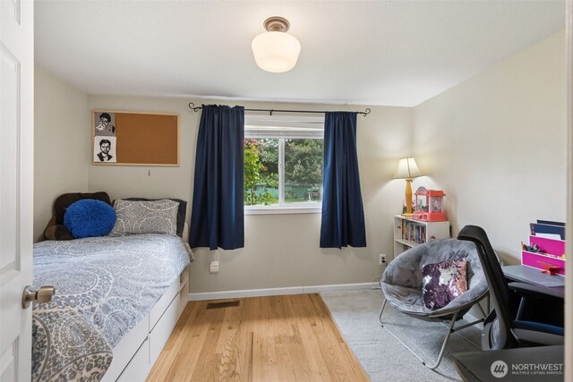 bedroom with wood finished floors and baseboards