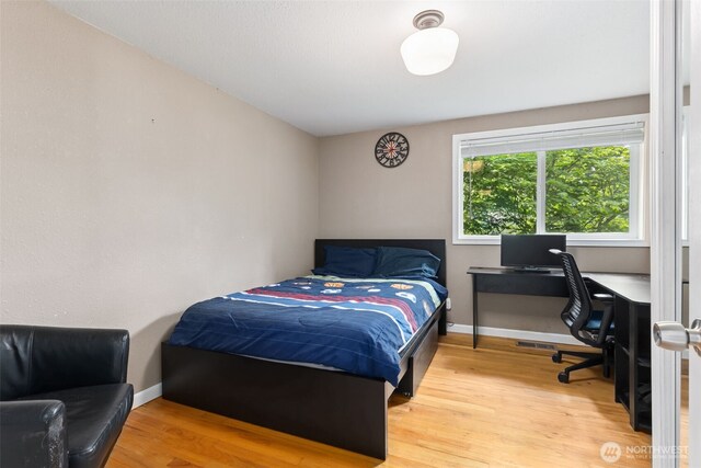 bedroom with wood finished floors, a desk, and baseboards