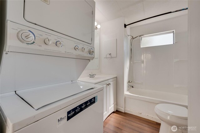 23708 Locust Way Unit 29, Bothell, WA 98102 - full bath with toilet, vanity, stacked washer and clothes dryer, wood finished floors, and bathing tub / shower combination