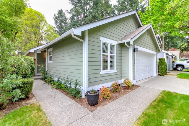 view of side of home featuring concrete driveway and an attached garage