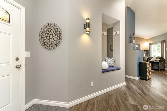 corridor featuring baseboards and wood finished floors