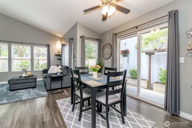 dining space featuring dark wood-type flooring, plenty of natural light, and lofted ceiling