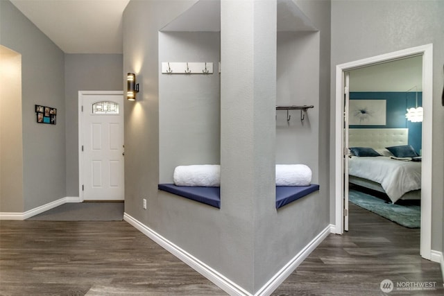 corridor with baseboards and wood finished floors