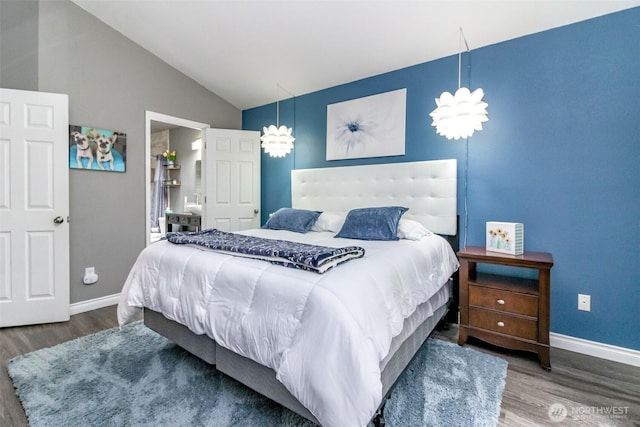 bedroom with baseboards, vaulted ceiling, and wood finished floors