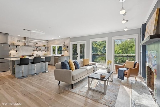 living room with recessed lighting, ornamental molding, french doors, and light wood finished floors