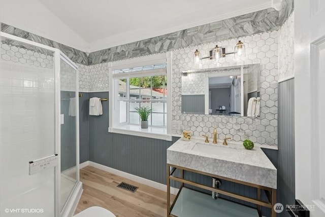full bath featuring vanity, visible vents, wood finished floors, a stall shower, and vaulted ceiling
