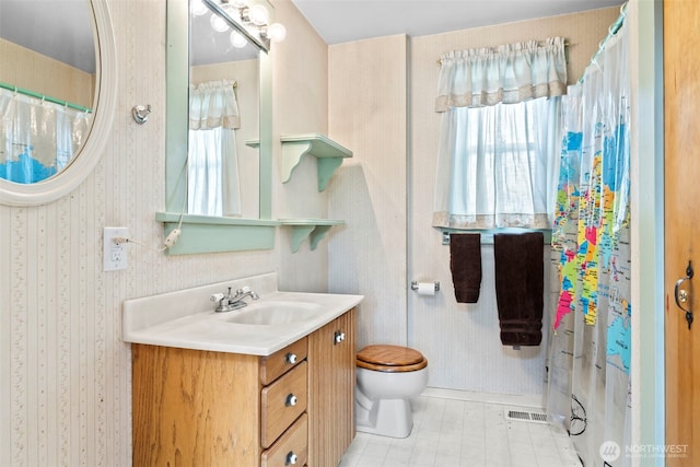 bathroom featuring vanity, toilet, baseboards, curtained shower, and visible vents