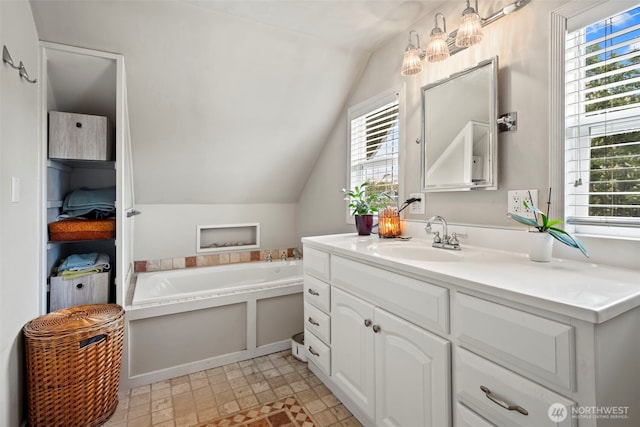 bathroom with a healthy amount of sunlight, lofted ceiling, and vanity