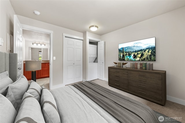 bedroom with baseboards, light carpet, ensuite bathroom, and a closet