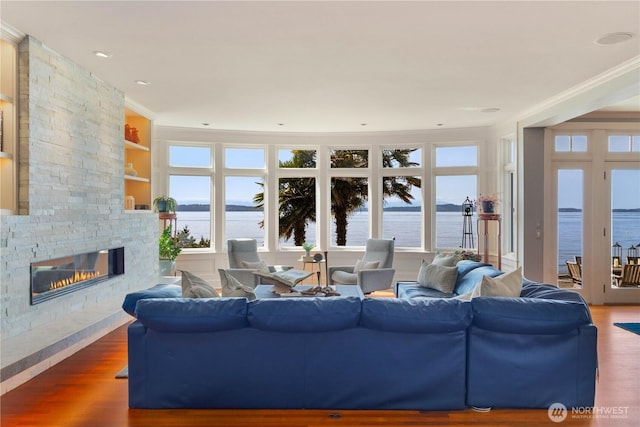 9325 Fauntleroy Way SW, Seattle, WA 98136 - living room featuring a stone fireplace, a water view, wood finished floors, and a healthy amount of sunlight