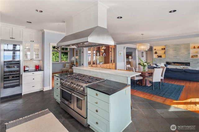 9325 Fauntleroy Way SW, Seattle, WA 98136 - kitchen featuring white cabinets, beverage cooler, wall chimney exhaust hood, range with two ovens, and open floor plan