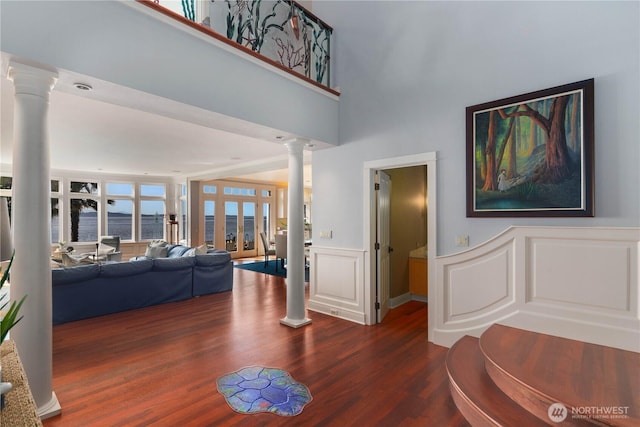9325 Fauntleroy Way SW, Seattle, WA 98136 - living area featuring decorative columns, a decorative wall, dark wood-type flooring, a water view, and a wainscoted wall