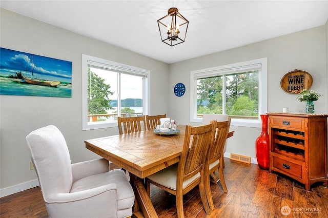 dining room with baseboards, dark wood-style flooring, a chandelier, and visible vents