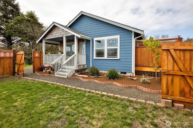 view of front of home with a gate, fence, and a front yard