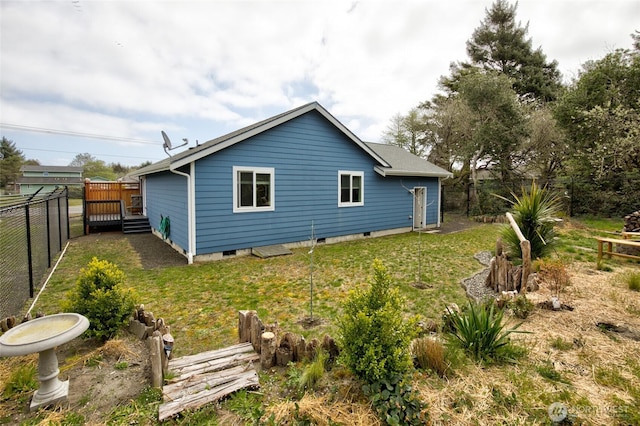 rear view of property with a yard, crawl space, and a fenced backyard