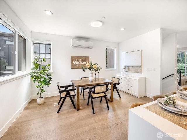 dining room featuring a wall mounted air conditioner, light wood-style flooring, baseboards, and recessed lighting